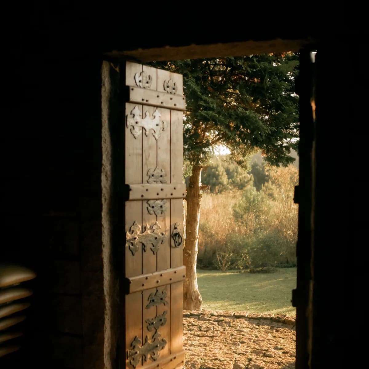 Porte ancienne ouverte sur un jardin ensoleillé