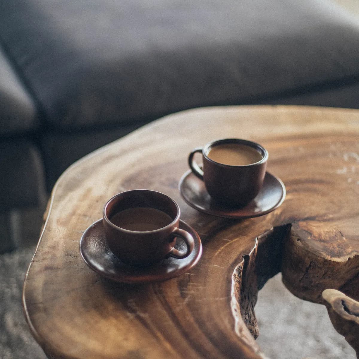 Deux tasses posées sur une table en bois brut